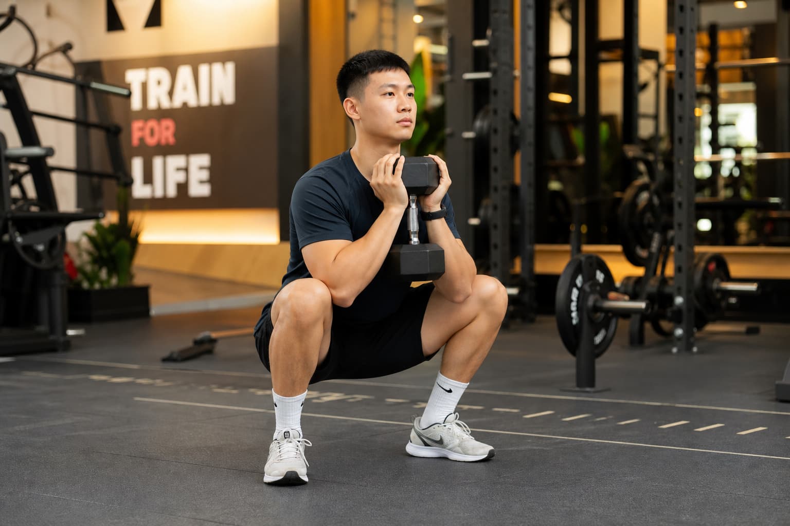 Người mới tập gym thực hiện động tác squat tạ với form đúng